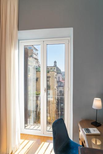 a chair in a room with a large window at Deluxe Spaccanapoli in Naples