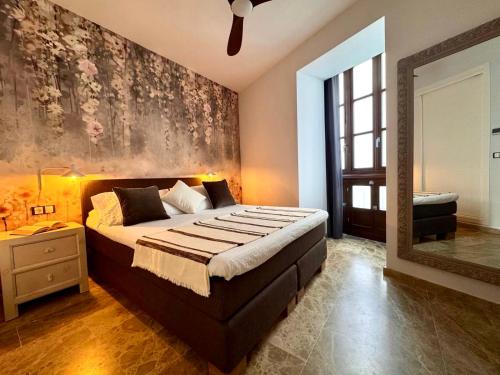 a bedroom with a large bed and a mirror at inncadiz El Refugio de Gadir in Cádiz