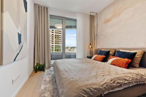une chambre avec un grand lit avec une grande fenêtre dans l'établissement SkyPark Apartment with City Views Free Parking, à Nivy