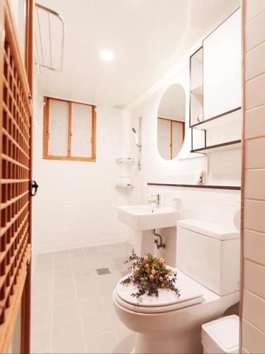 a bathroom with a sink and a toilet with flowers on it at #오픈할인# 경복궁역 도보 4분#한옥#전통체험#경복궁,인사동,북촌,서촌,광화문,명동, 동대문 바로 옆#짐보관# 9인#호텔침구#각방에어컨#무료와이파이#세탁건조기#교통최고 in Seoul