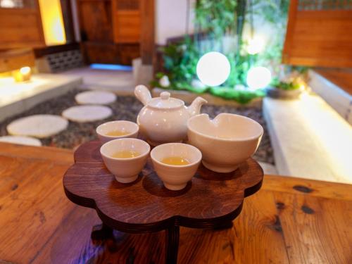 a table with four bowls and a tea set on it at #오픈할인# 경복궁역 도보 4분#한옥#전통체험#경복궁,인사동,북촌,서촌,광화문,명동, 동대문 바로 옆#짐보관# 9인#호텔침구#각방에어컨#무료와이파이#세탁건조기#교통최고 in Seoul