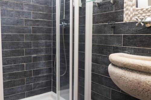 a bathroom with a glass shower and a sink at Régi Posta Hotel és Étterem in Debrecen