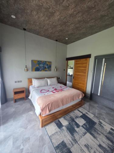 a bedroom with a large bed in a room at MAYURA BALI VILLA in Munduk