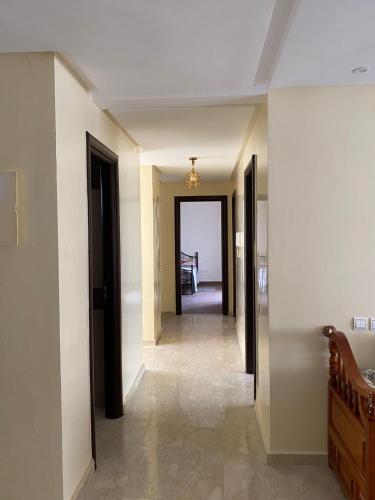 a hallway with a hallway leading to a room with a table at appartement cité marine plage 5min in O Ben Slimane