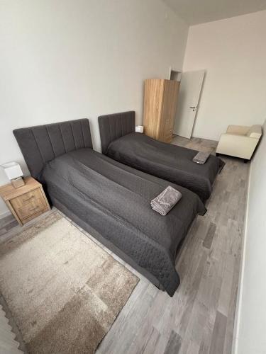 a bedroom with two beds and a couch at Újszerű, jól felszerelt lakás a város szîvében, ingyenes parkolással! in Debrecen