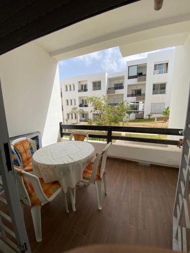 a balcony with a table and chairs and a building at appartement cité marine plage 5min in O Ben Slimane