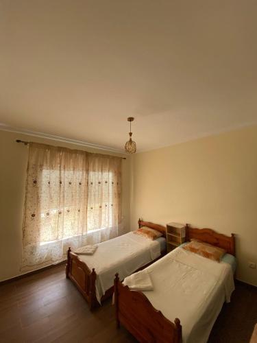 a bedroom with two beds and a window at appartement cité marine plage 5min in O Ben Slimane
