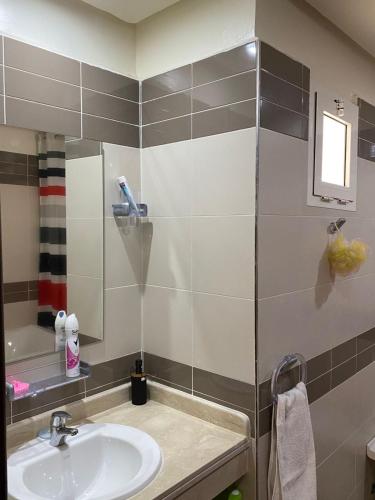 a bathroom with a sink and a mirror at appartement cité marine plage 5min in O Ben Slimane