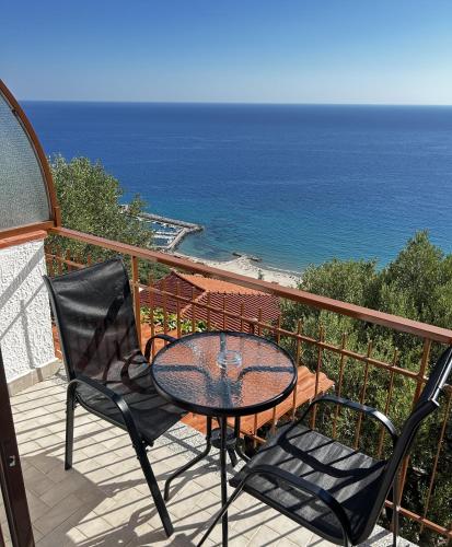 a table and chairs on a balcony with the ocean at Belvedere in Pisciotta