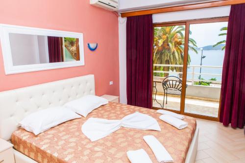 a bedroom with a bed with a view of the ocean at Hotel Pini in Sarandë