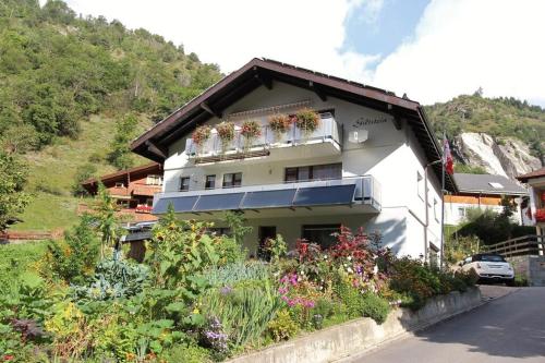 Un edificio blanco con flores delante. en Ferienwohnung Giltstein in Mörel, en Mörel