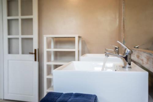 a bathroom with a white sink and a door at Villa Céleste - 4 Bedrooms in Central Tamarin in Tamarin