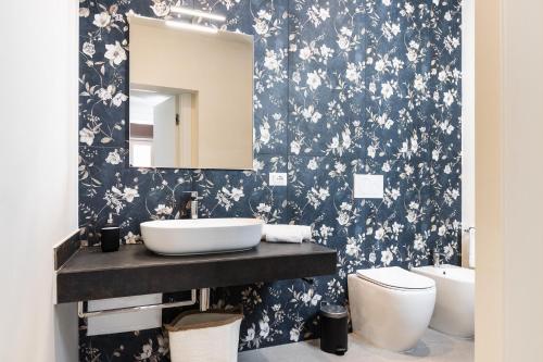 a bathroom with a black and white floral wallpaper at Palazzo Giangreco Luxury Rooms in Avola