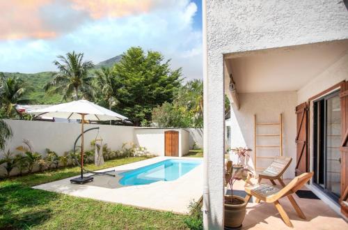 a backyard with a swimming pool and a house at Villa Céleste - 4 Bedrooms in Central Tamarin in Tamarin