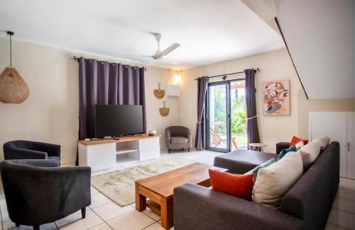 a living room with a couch and a tv at Villa Céleste - 4 Bedrooms in Central Tamarin in Tamarin