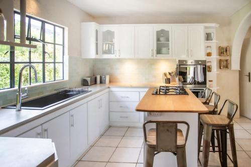 a kitchen with white cabinets and a wooden counter top at Villa Céleste - 4 Bedrooms in Central Tamarin in Tamarin