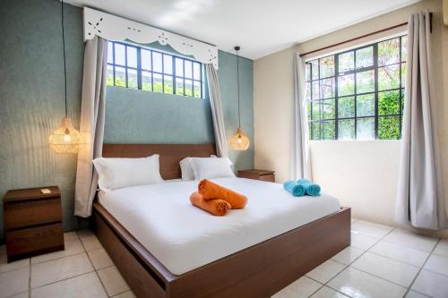 a bedroom with a bed with an orange teddy bear on it at Villa Céleste - 4 Bedrooms in Central Tamarin in Tamarin