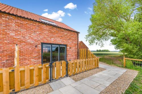 a red brick building with a wooden fence at 1 Bed in Marishes oc-l32534 in Kirby Misperton