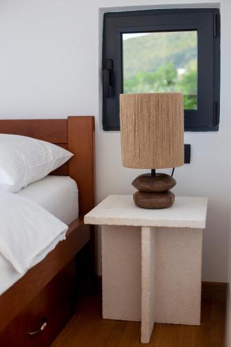 a table with a lamp on it next to a bed at Casa del Sol Zagora in Zagora