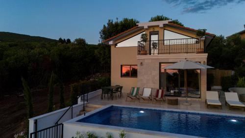 a villa with a swimming pool in front of a house at Casa del Sol Zagora in Zagora
