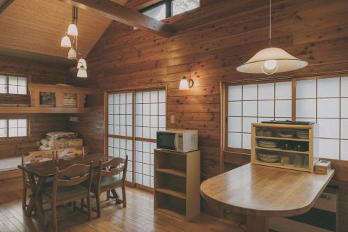 eine Küche und ein Esszimmer mit Tisch und Stühlen in der Unterkunft 鬼無里の湯 ホテル&コテージ in Nagano