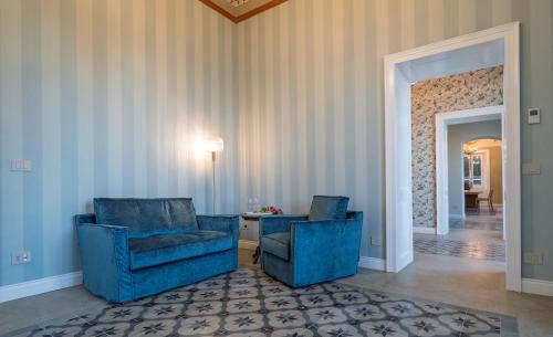 two blue chairs and a table in a room at Villa Mabel Boutique Hotel in Taormina