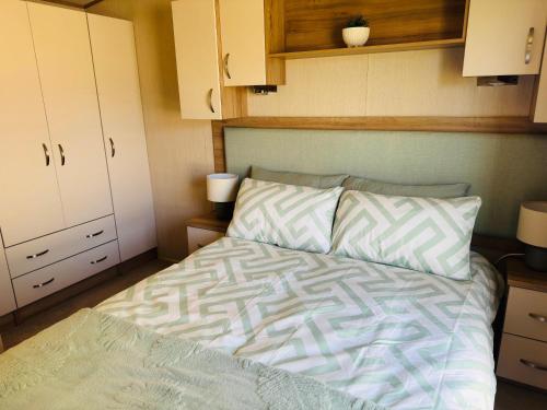a bed in a small room with white cabinets at Cosy 2 bed in Dovercourt Holiday Park -Sleeps 6 in Harwich
