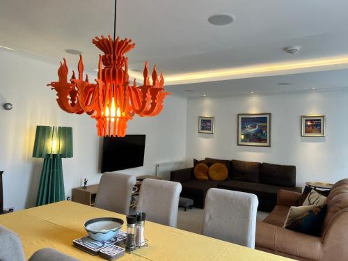 a living room with a table and a chandelier at Crieff Armoury in Crieff