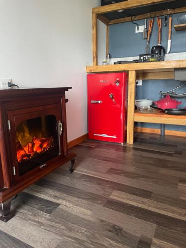 a kitchen with a fireplace and a red refrigerator at Luz de Luna Antilhue in Valdivia