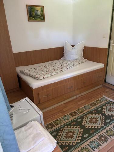 a small bed in a room with a rug at Pensiunea Anca Sapanta-primeste carduri de vacanta in Săpînţa
