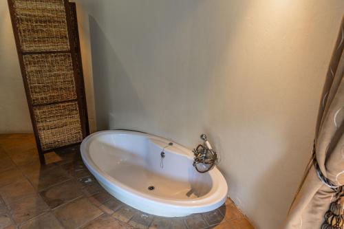 a bath tub sitting in a bathroom with at Premier Resort Mpongo Private Game Reserve in Macleantown