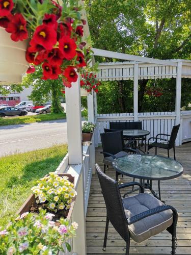 a patio with tables and chairs and red flowers at Hotel Turistihovi in Kouvola
