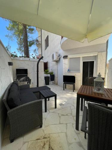 a patio with a couch and a table and a piano at Seaesta holiday- Modern studio in Okrug Gornji