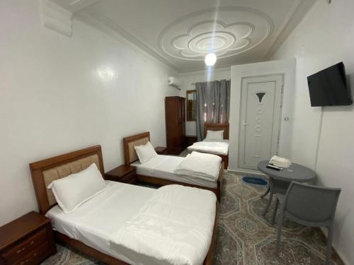 a room with two beds and a table in it at Family Lounge in Matriouene