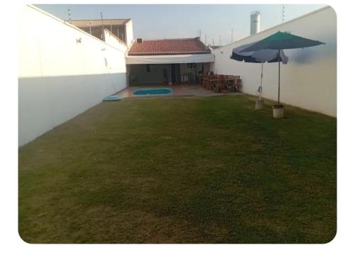 a patio with an umbrella next to a building at aconchego da Lenna in Juazeiro do Norte