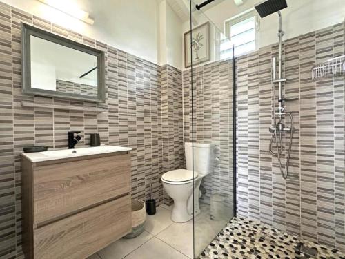 Un baño con inodoro, lavabo y ducha. en CARIBEENNES Villa TiZoun, en Saint-François