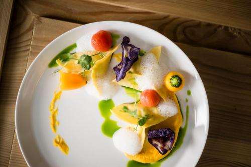 a white plate of food on a table at Mirabell Dolomites Hotel - Luxury Ayurveda & Spa in Valdaora