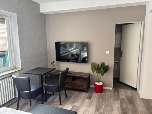 a living room with a table and a television on a wall at Vastus homes in Duisburg