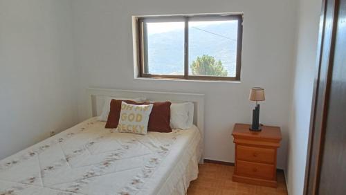 a small bedroom with a bed with a window at Private Pool River View Villa in Baião