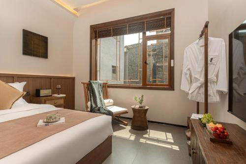 a hotel room with a bed and a window at 凤凰古城树喜民宿店Shuxi Guesthouse- Fenghuang Ancient Town in Fenghuang