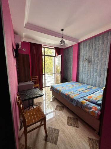 a bedroom with a bed and a table and a chair at Hotel Lile in Ureki