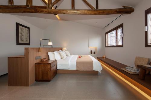 a bedroom with a bed and a table and two windows at 凤凰古城树喜民宿店Shuxi Guesthouse- Fenghuang Ancient Town in Fenghuang