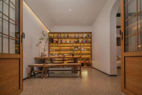a dining room with a table and a shelf of wine bottles at 凤凰古城树喜民宿店Shuxi Guesthouse- Fenghuang Ancient Town in Fenghuang