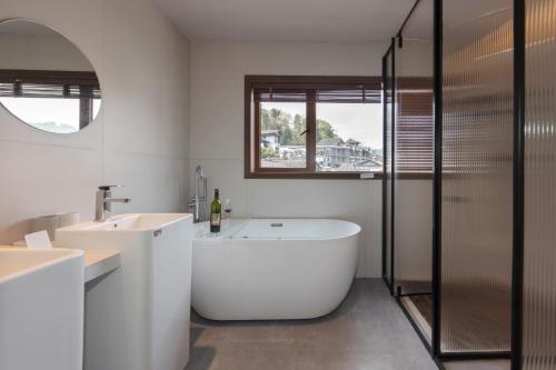 a white bathroom with a tub and a sink at 凤凰古城树喜民宿店Shuxi Guesthouse- Fenghuang Ancient Town in Fenghuang