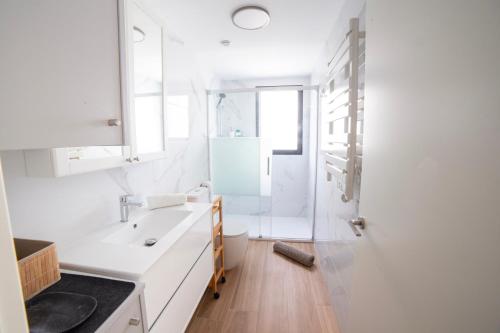 une salle de bain blanche avec lavabo et douche dans l'établissement Gandia Playa Moderna - nuevo con piscina y parking, 2 banos, playa 300 m, grau 300 m, à Playa de Gandia