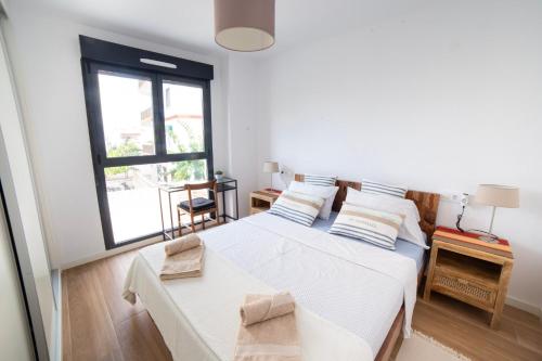 une chambre avec deux lits et une fenêtre dans l'établissement Gandia Playa Moderna - nuevo con piscina y parking, 2 banos, playa 300 m, grau 300 m, à Playa de Gandia