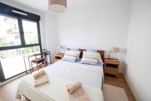 a bedroom with two beds and a large window at Gandia Playa Moderna - nuevo con piscina y parking, 2 banos, playa 300 m, grau 300 m in Playa de Gandia