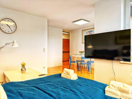 a bedroom with a blue bed and a clock on a wall at Stilvolle Maisonette in Neuss - Balkon & Gratis-Parkplatz in Neuss