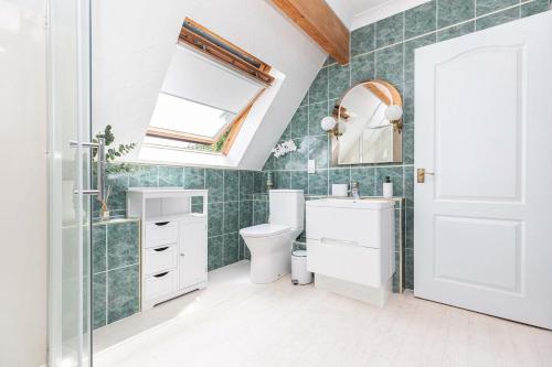 a bathroom with a toilet and a sink and a mirror at MOONGATE by BOURNECOAST - A Delightful Chalet Bungalow with a Garden and Parking - HB10672 in Christchurch