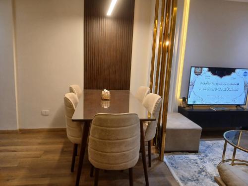 a dining room with a table and chairs and a tv at Dar Residence - Madinaty B12 - U2 - 2 BR - New Cairo in Madinaty